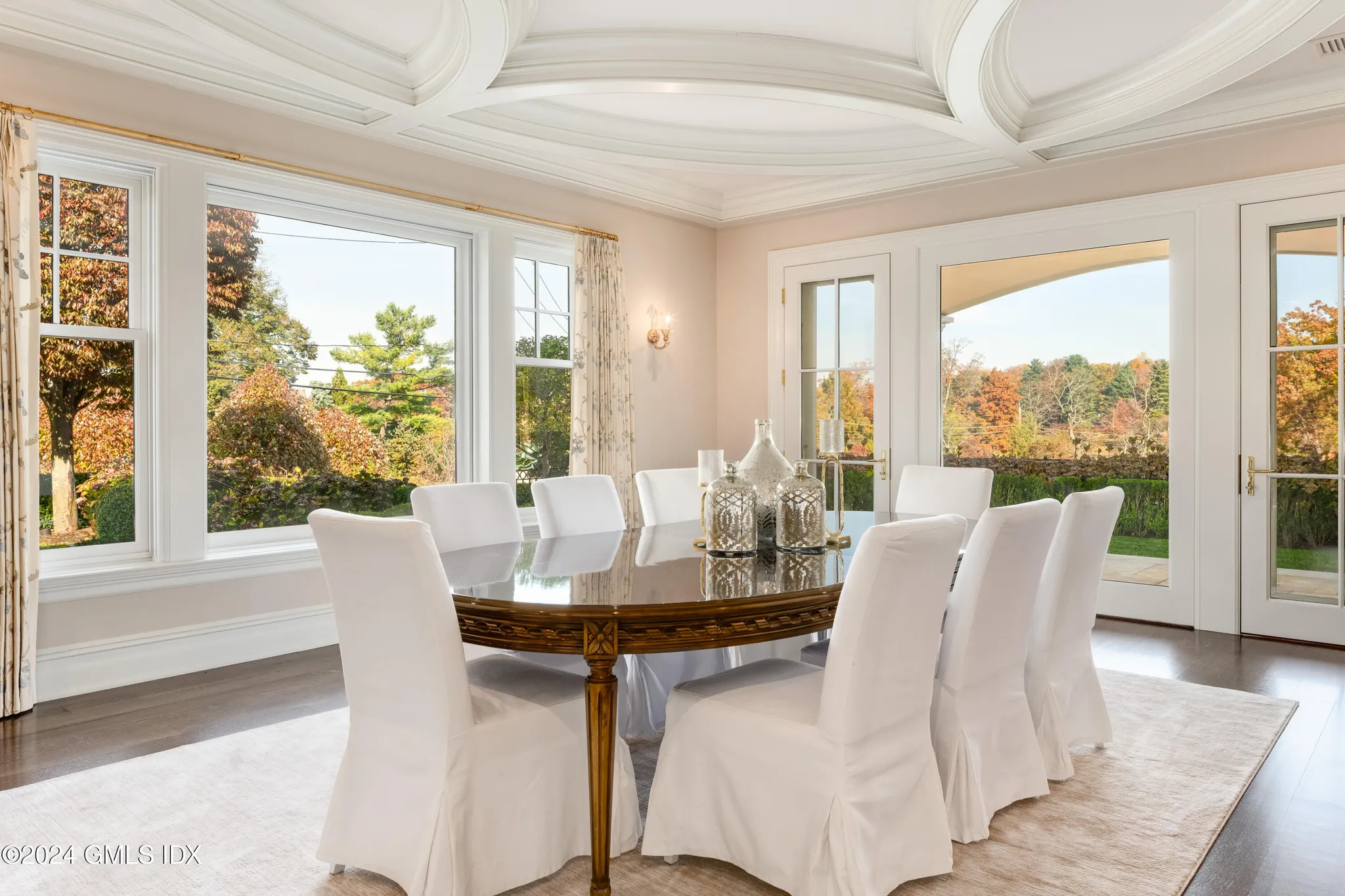 Light-filled dining room with white seating and a tray ceiling