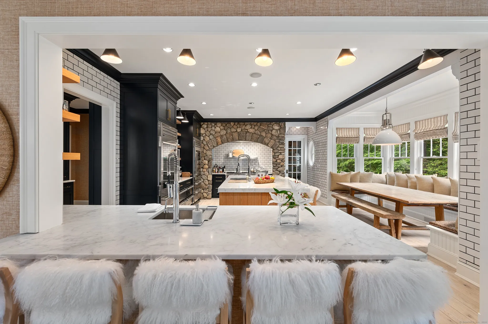 Open kitchen with a stone island and timber ceiling details